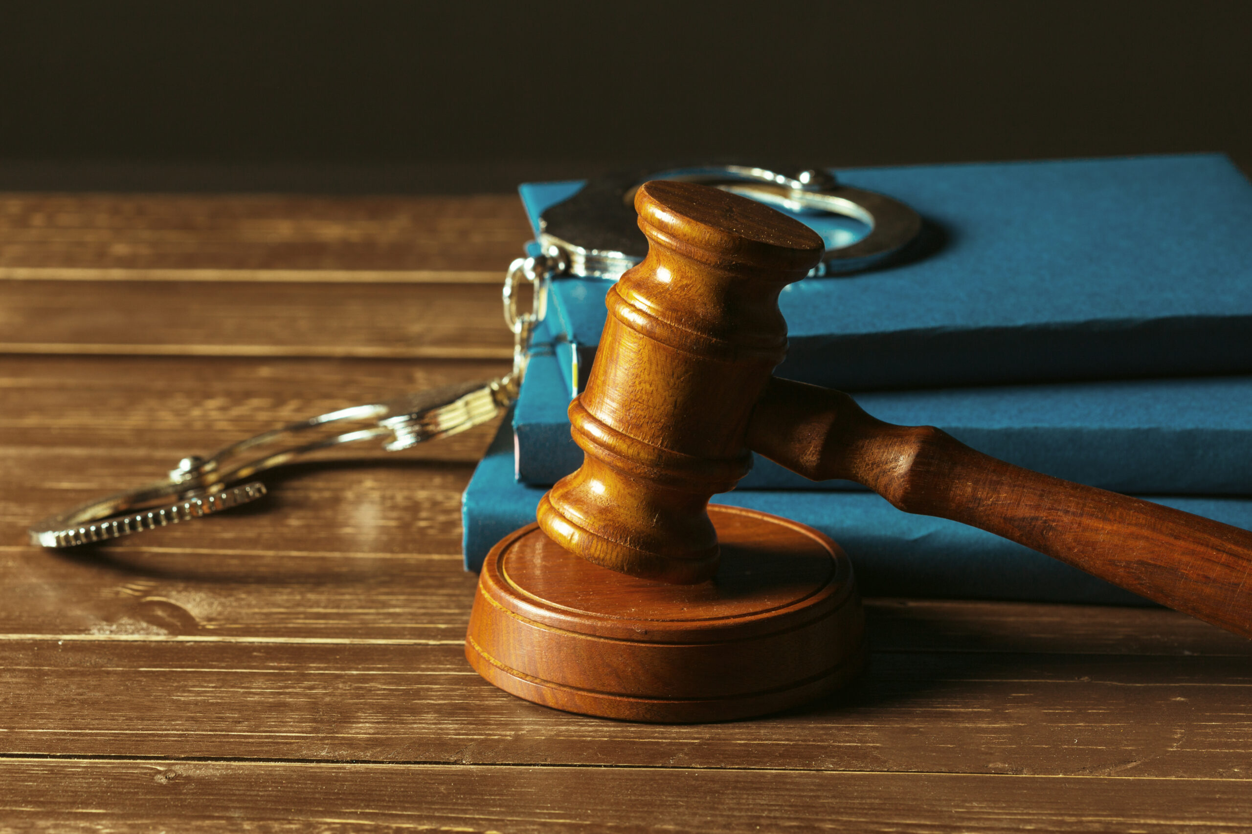 Gavel With Handbooks On Old Wooden Desk